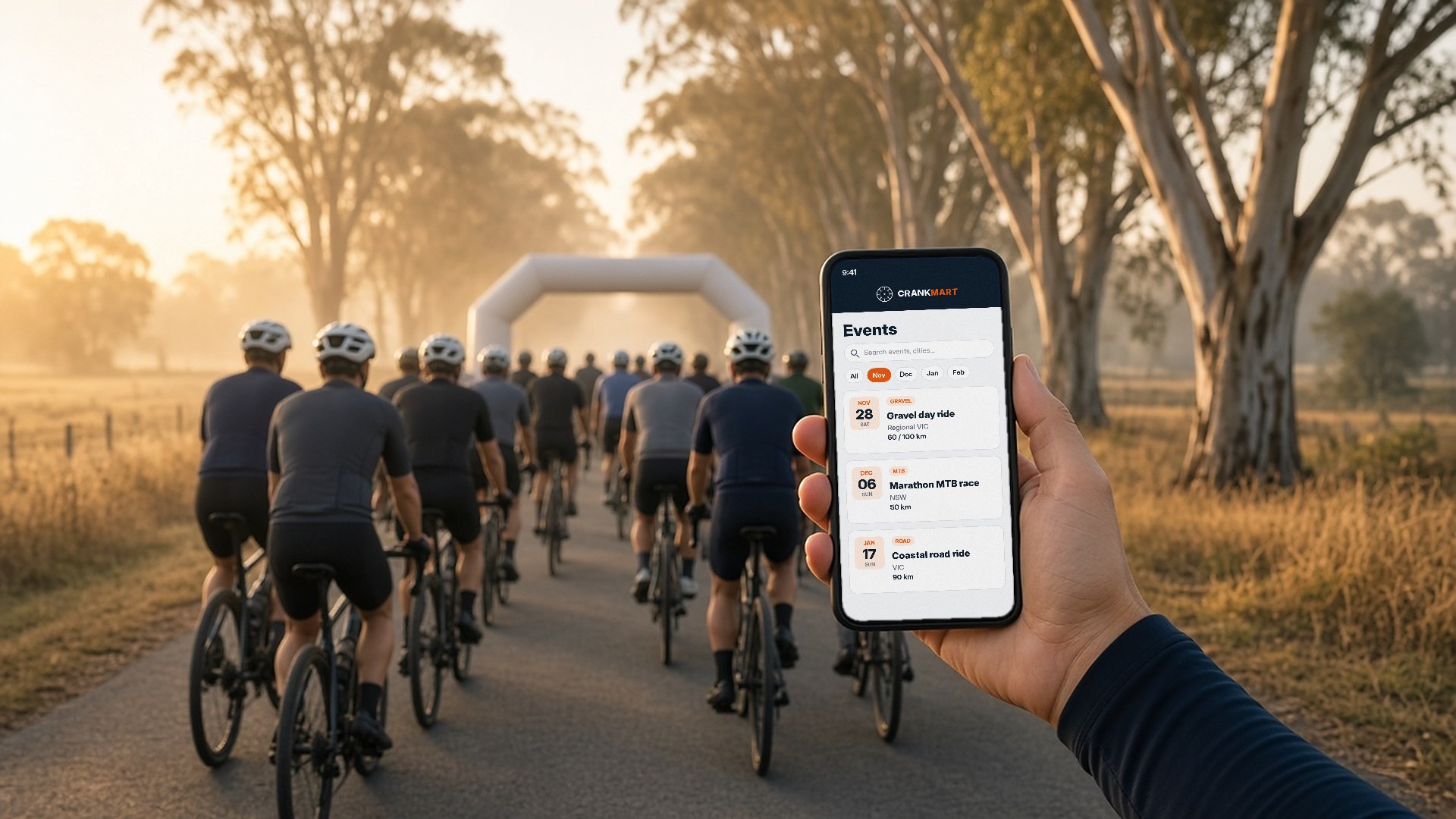 Riders rolling off from the start of a cycling event on a gum-lined country road in Australia, with CrankMart event listings on a phone in the foreground